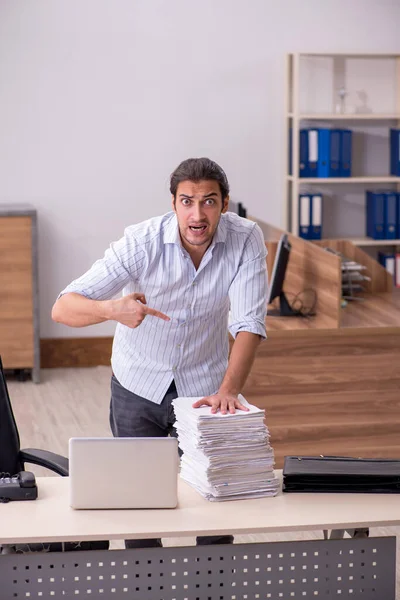 Joven empleado masculino infeliz con el trabajo excesivo — Foto de Stock