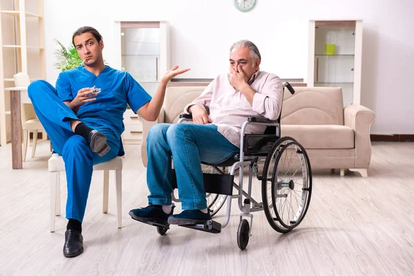 Tekerlekli sandalyedeki yaşlı adam ve genç kötü bakıcı.