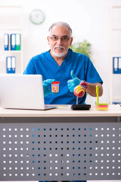 Gammal manlig läkare farmaceut som arbetar på kliniken — Stockfoto