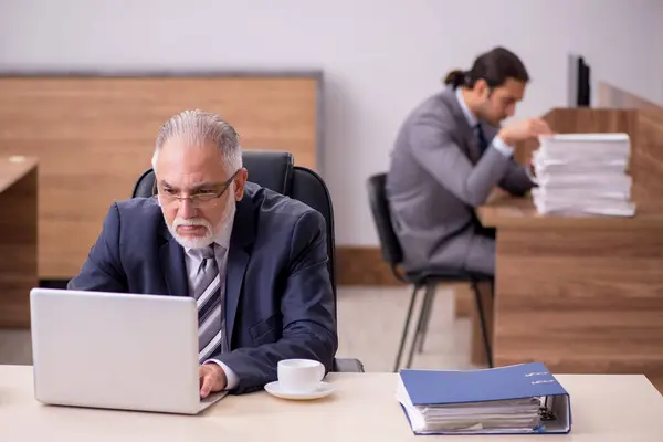 Antiguo jefe y joven asistente masculino en la oficina —  Fotos de Stock