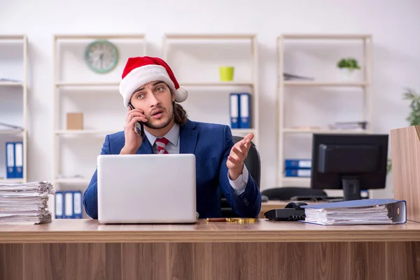 Young male employee working in the office at Christmas Eve — Stock Photo, Image