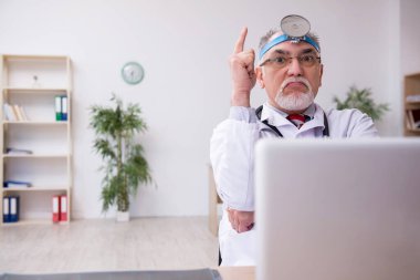 Klinikte çalışan yaşlı erkek doktor otolog.