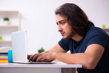 Evden çalışan genç bir adam.