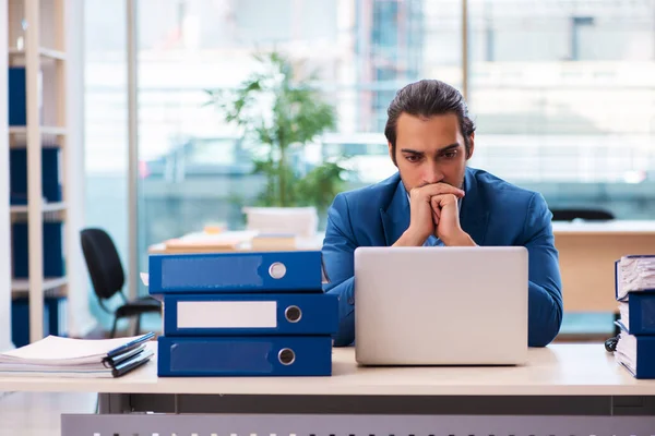 Ung manlig anställd och för mycket arbete på kontoret — Stockfoto