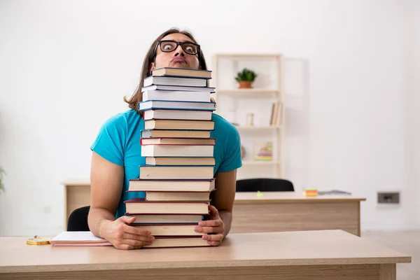 Giovane studente maschio e un sacco di libri in classe — Foto Stock