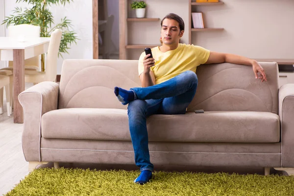 Jovem estudante falando por telefone em casa — Fotografia de Stock