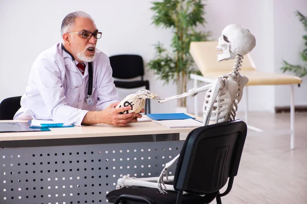 Alte männliche Arzt Kardiologe und Skelett-Patient in teuren m — Stockfoto
