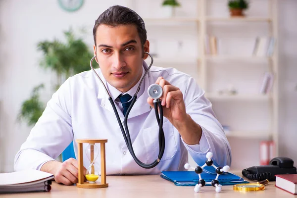 Ung manlig läkare i time management koncept — Stockfoto