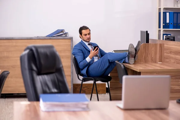 Junge männliche Mitarbeiter sitzen am Arbeitsplatz — Stockfoto