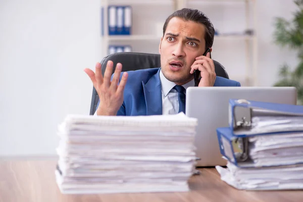 Jonge mannelijke werknemer ongelukkig met overmatig werk — Stockfoto