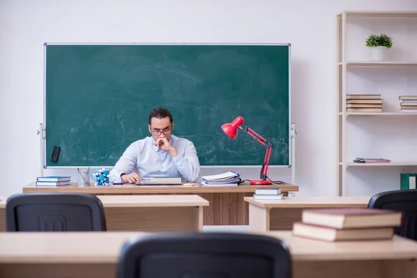 Jonge mannelijke leraar in de voorkant van groene boord — Stockfoto