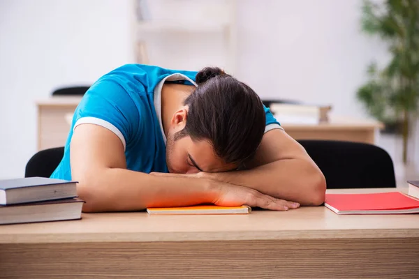 Wyczerpany student przygotowujący się do egzaminów w klasie — Zdjęcie stockowe
