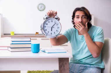 Genç erkek öğrenci zaman yönetimi konsepti sınavlarına hazırlanıyor.