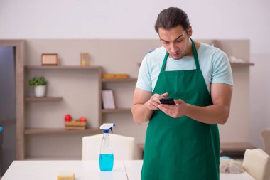 Genç erkek müteahhit evi temizliyor.