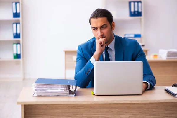 Junge männliche Mitarbeiter und zu viele Arbeit im Büro — Stockfoto