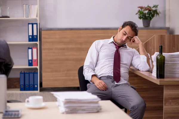 Junge männliche Angestellte trinkt Alkohol im Büro — Stockfoto