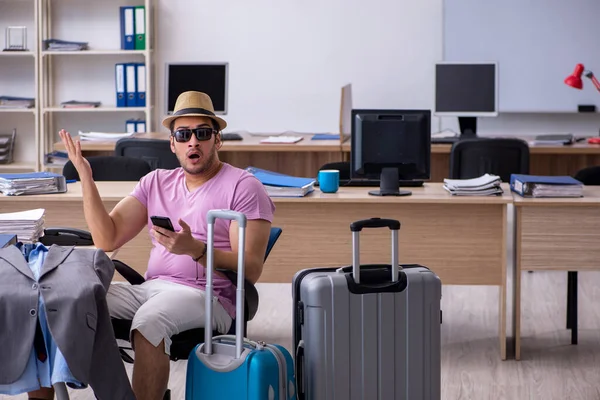 Young male employee preparing for the trip — Stock Photo, Image