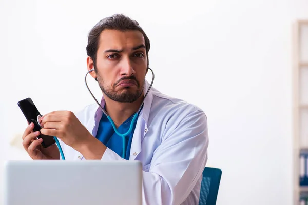 Jovem médico masculino segurando fonendoscópio — Fotografia de Stock