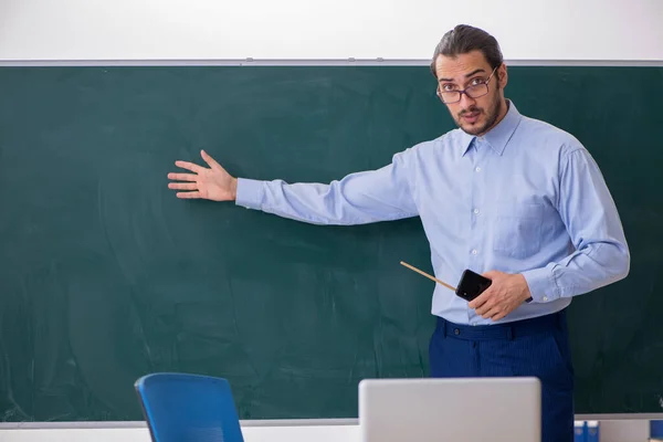 Joven profesor en el aula delante de la mesa verde —  Fotos de Stock