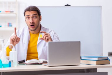 Genç erkek kimyager sınava hazırlanıyor.