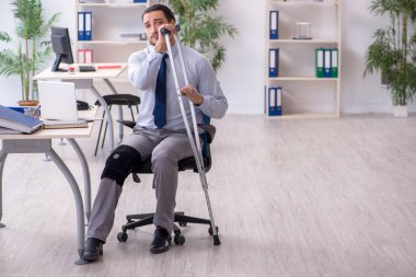 Ofiste çalışan genç bacağı yaralı bir çalışan.