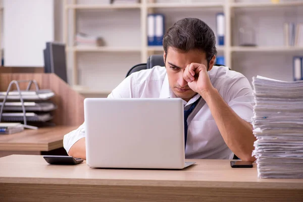 Jovem funcionário masculino infeliz com excesso de trabalho no escritório — Fotografia de Stock