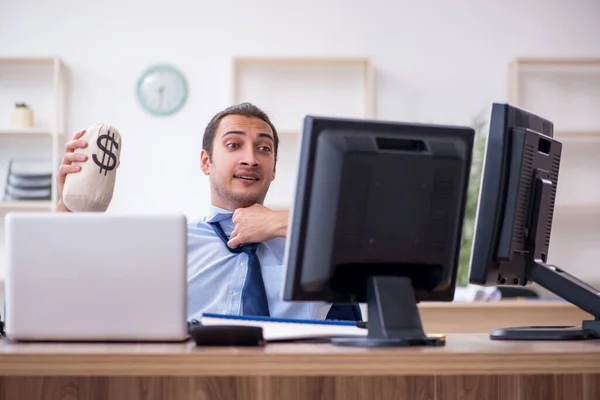 Jonge mannelijke werknemer met geldzak in het kantoor — Stockfoto