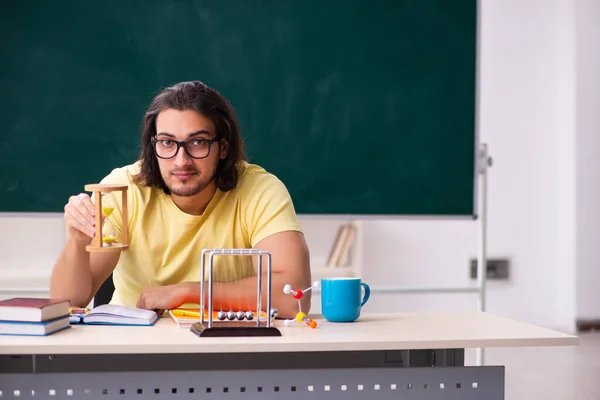 Ung manlig elev fysiker förbereder sig för tentor i klassrummet — Stockfoto