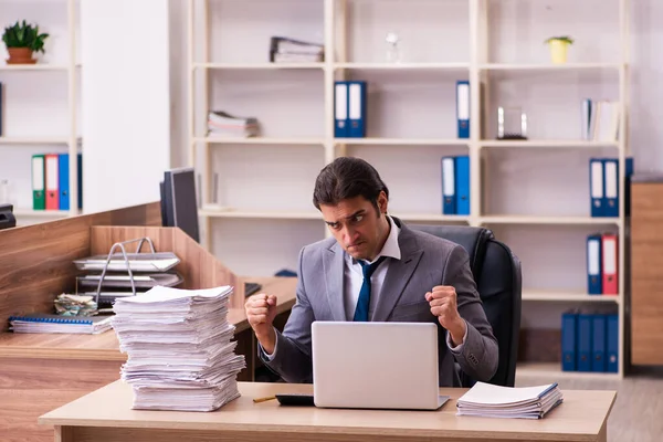 Jovem funcionário masculino infeliz com excesso de trabalho no escritório — Fotografia de Stock