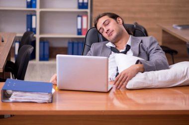 İş yerinde uyuyan genç bir erkek işçi.