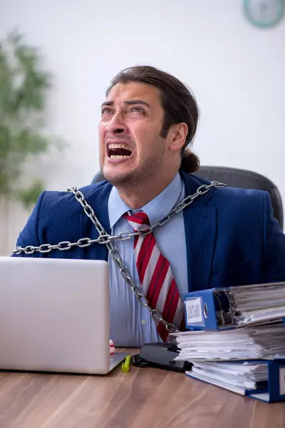 Angeketteter männlicher Mitarbeiter unzufrieden mit exzessiver Arbeit im Büro — Stockfoto