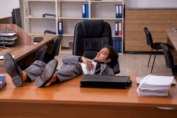 Joven empleado masculino durmiendo en el lugar de trabajo —  Fotos de Stock