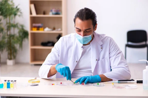 Joven químico masculino trabajando en el laboratorio durante una pandemia —  Fotos de Stock