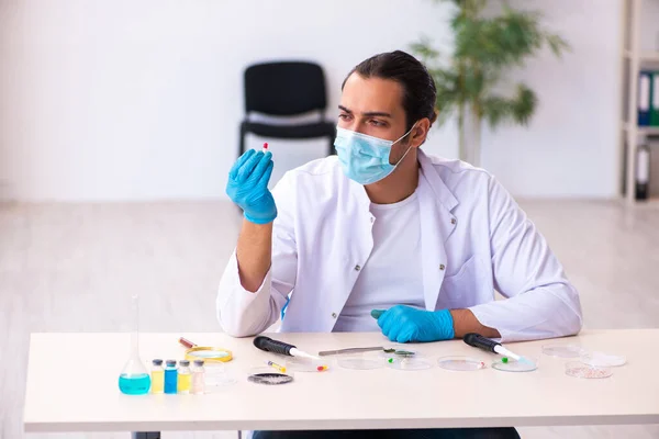 Jovem químico do sexo masculino trabalhando no laboratório durante a pandemia — Fotografia de Stock