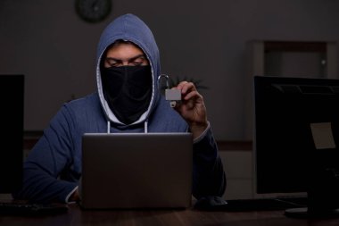 Erkek bilgisayar korsanı, güvenlik duvarını geç saatlerde hackliyor.