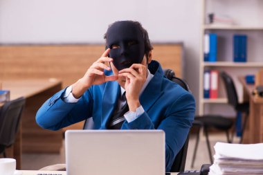 Ofiste maske takan genç bir erkek.