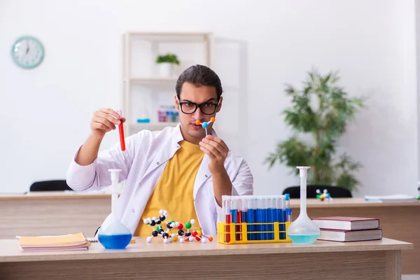 Young male chemist studying molecular model in the classroom — Stock Photo, Image