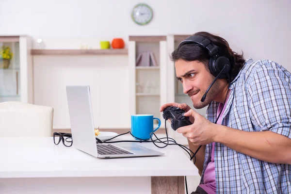Jovem estudante do sexo masculino jogando jogos de computador em casa — Fotografia de Stock
