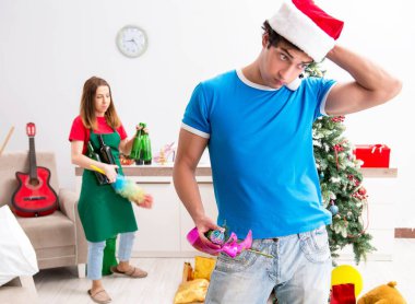 Noel partisinden sonra genç bir aile evi temizliyor.