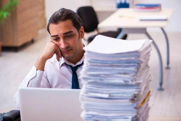 Joven empleado masculino infeliz con el trabajo excesivo — Foto de Stock