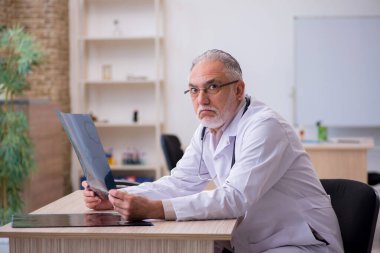 Klinikte çalışan yaşlı bir erkek radyolog.