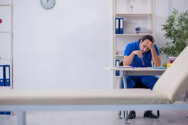 Jovem médico do sexo masculino sendo extremamente cansado na clínica — Fotografia de Stock