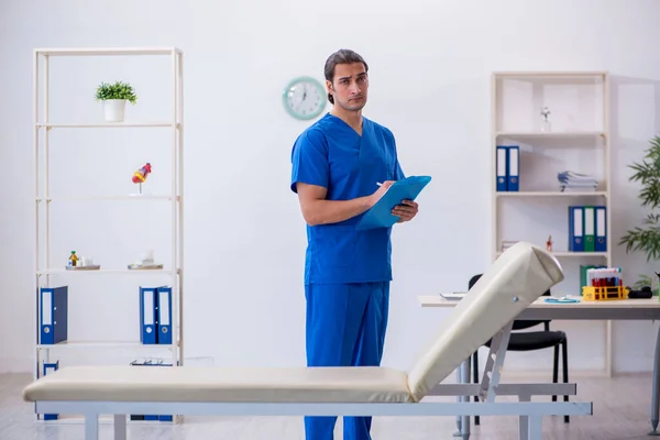 Young male doctor taking notes at the hospital — Stock Photo, Image