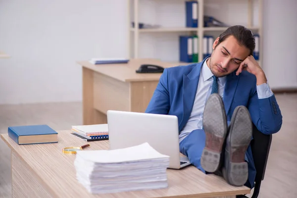 Jeune employé masculin et trop de travail au bureau — Photo