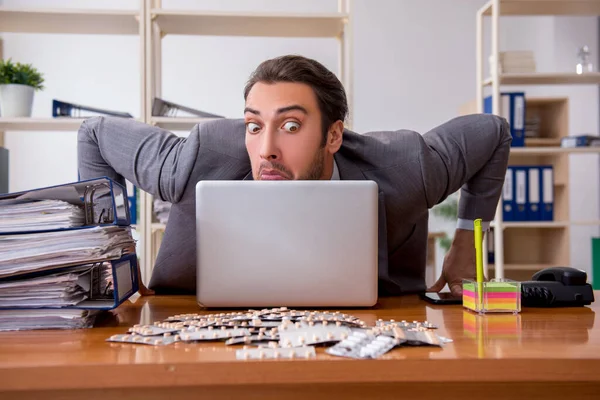 Ung manlig sjuk anställd som lider på arbetsplatsen — Stockfoto