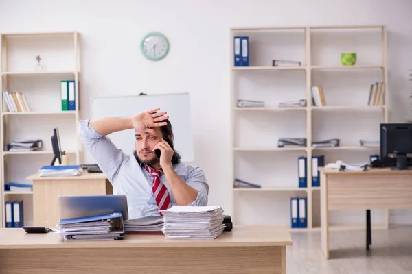 Joven empleado masculino infeliz con el trabajo excesivo — Foto de Stock