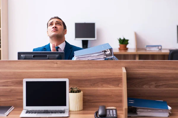 Mladý muž zaměstnanec nešťastný s nadměrnou prací v kanceláři — Stock fotografie