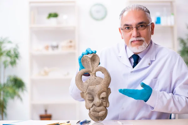 Старший археолог, изучающий древнюю африканскую каменную маску — стоковое фото