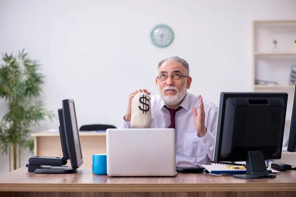 Vecchio capo maschio seduto sul desktop in ufficio — Foto Stock