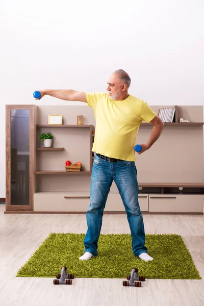 Yaşlı adam evde spor egzersizleri yapıyor. — Stok fotoğraf